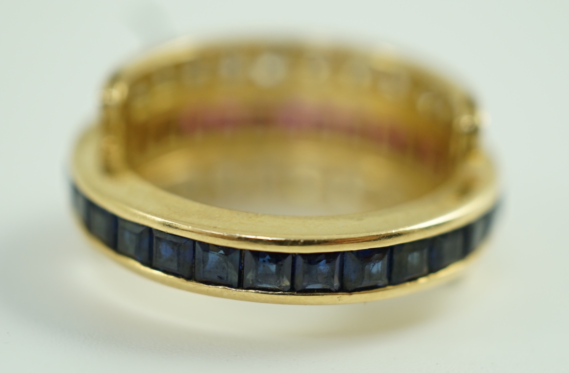 An 18k gold, ruby, sapphire and diamond set triple band swivel ring